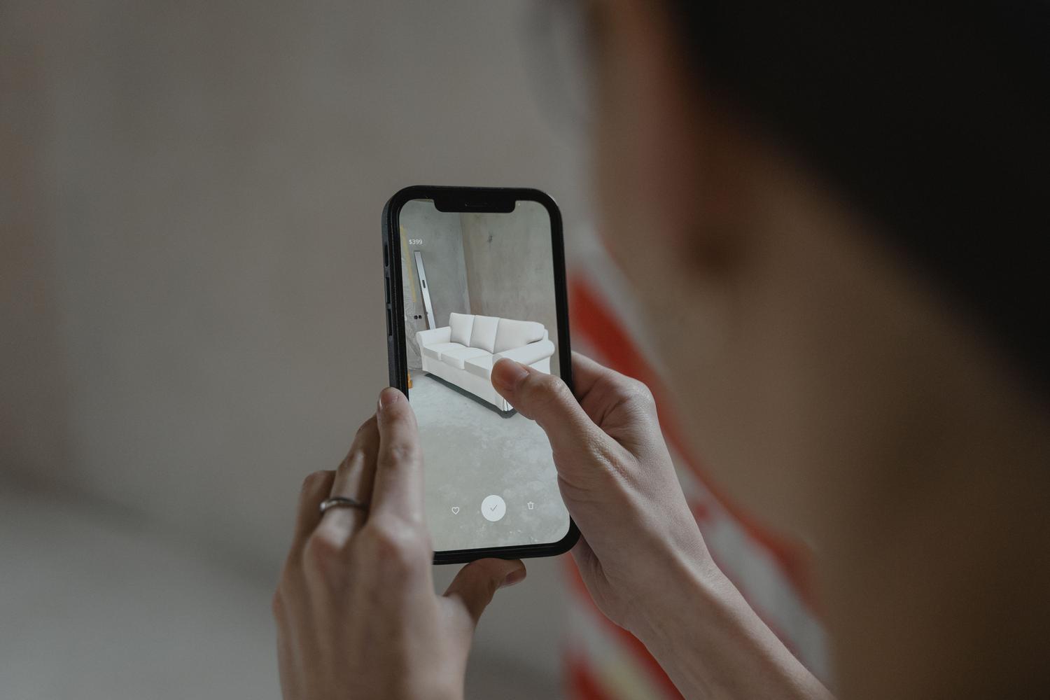 Uso de realidad aumentada en un smartphone para visualizar un mueble virtual superpuesto en una habitación real. Uso de realidad aumentada en un smartphone para visualizar un mueble virtual superpuesto en una habitación real.
