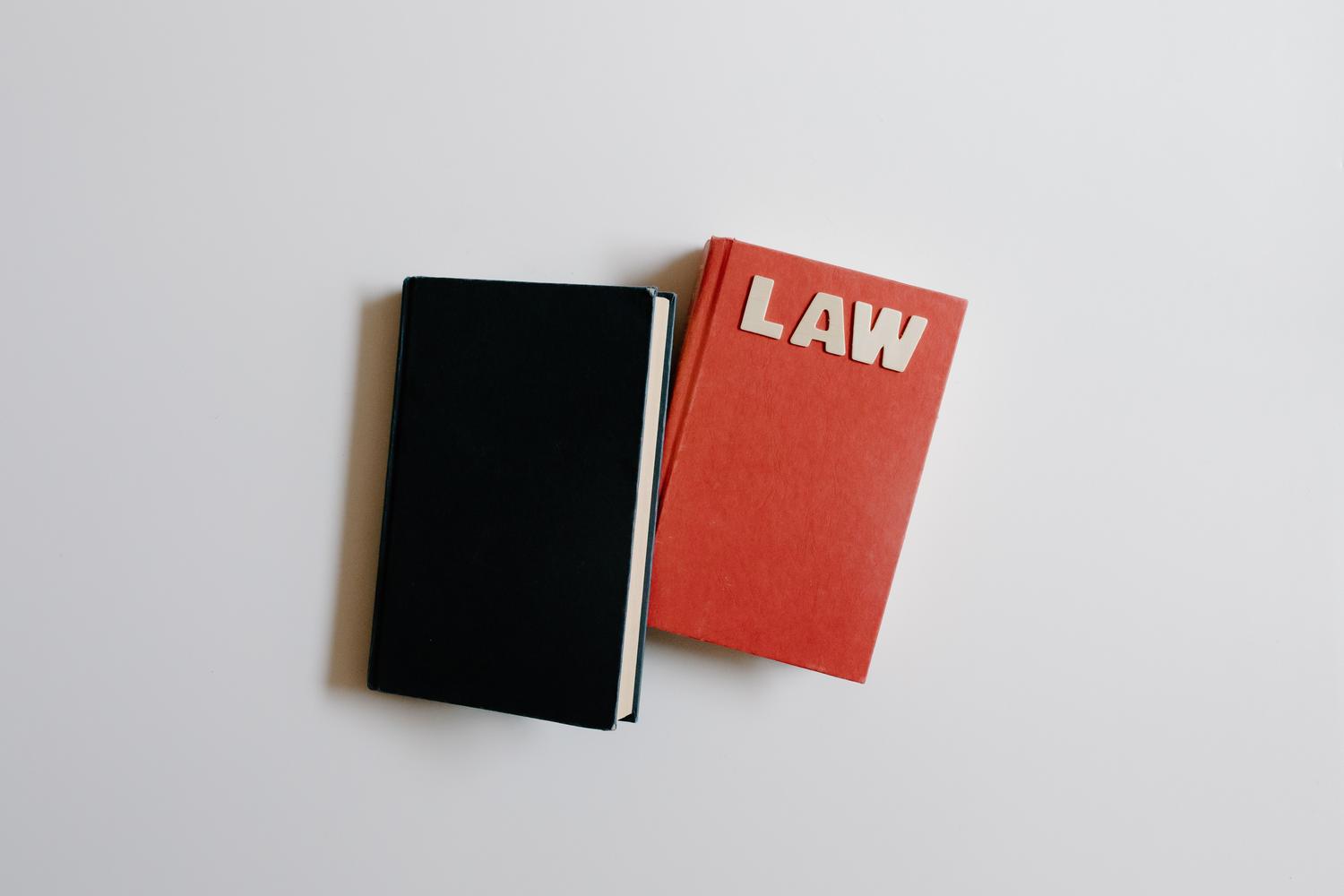 Vista cenital minimalista de un libro de leyes y un cuaderno sobre fondo blanco, ideal para temas de citación académica. Vista cenital minimalista de un libro de leyes y un cuaderno sobre fondo blanco, ideal para temas de citación académica.