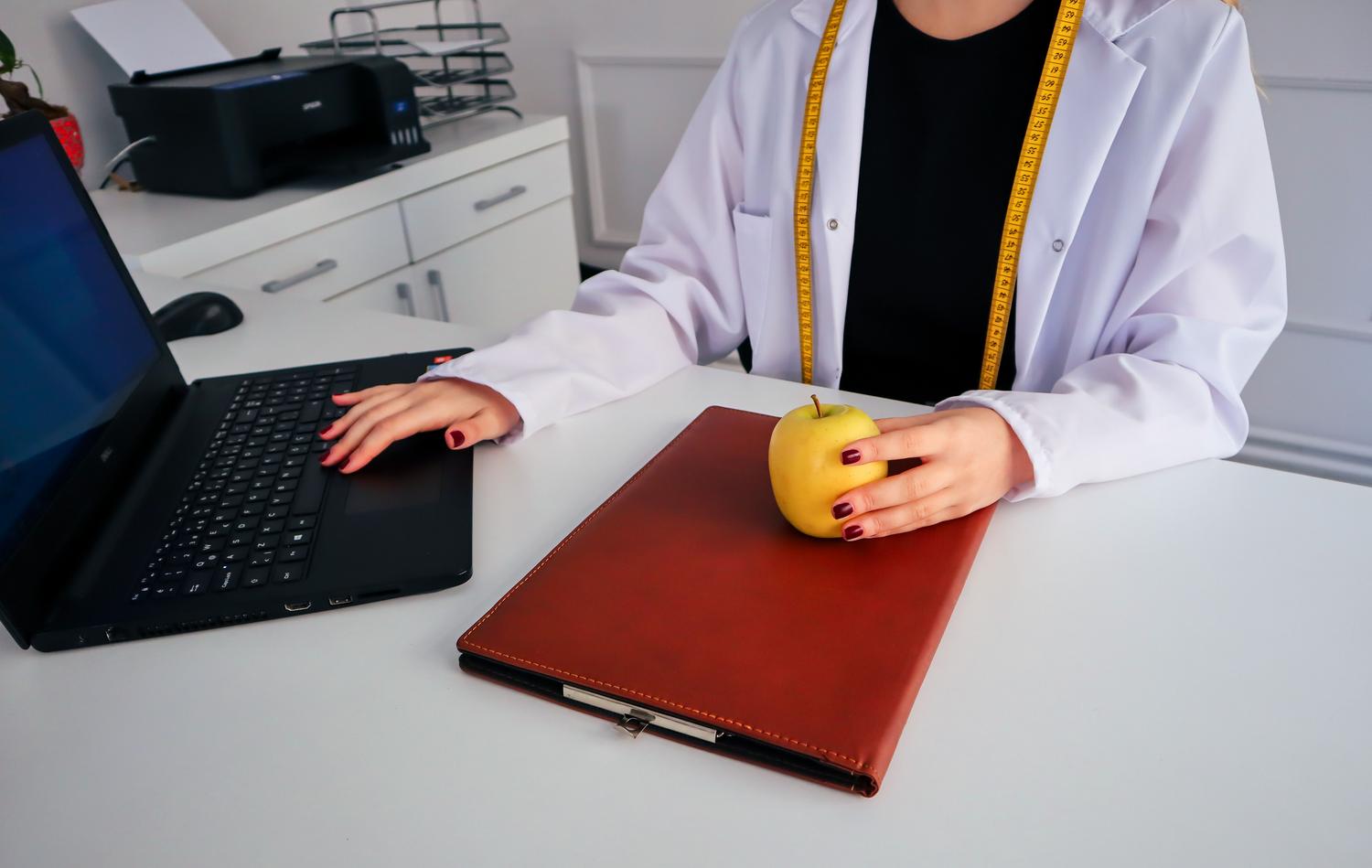 Profesional de la nutrición utilizando un ordenador portátil, ilustrando la metodología de formación online y campus virtuales. Profesional de la nutrición utilizando un ordenador portátil, ilustrando la metodología de formación online y campus virtuales.