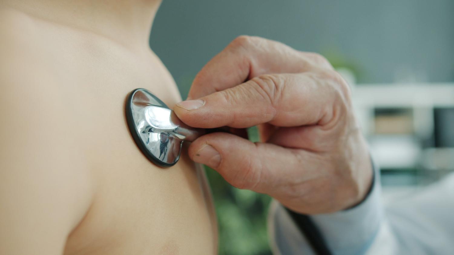 Primer plano de un cardiólogo pediátrico auscultando el corazón de un niño con un estetoscopio Primer plano de un cardiólogo pediátrico auscultando el corazón de un niño con un estetoscopio