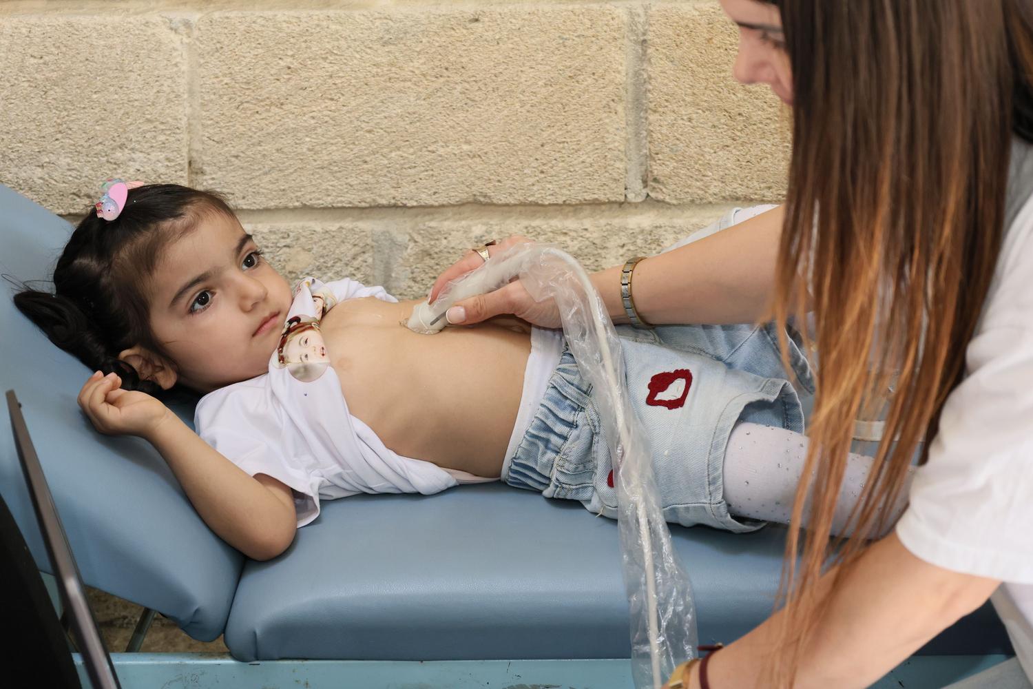 Niña recibiendo una ecocardiografía Doppler en una clínica pediátrica para el diagnóstico cardiovascular Niña recibiendo una ecocardiografía Doppler en una clínica pediátrica para el diagnóstico cardiovascular