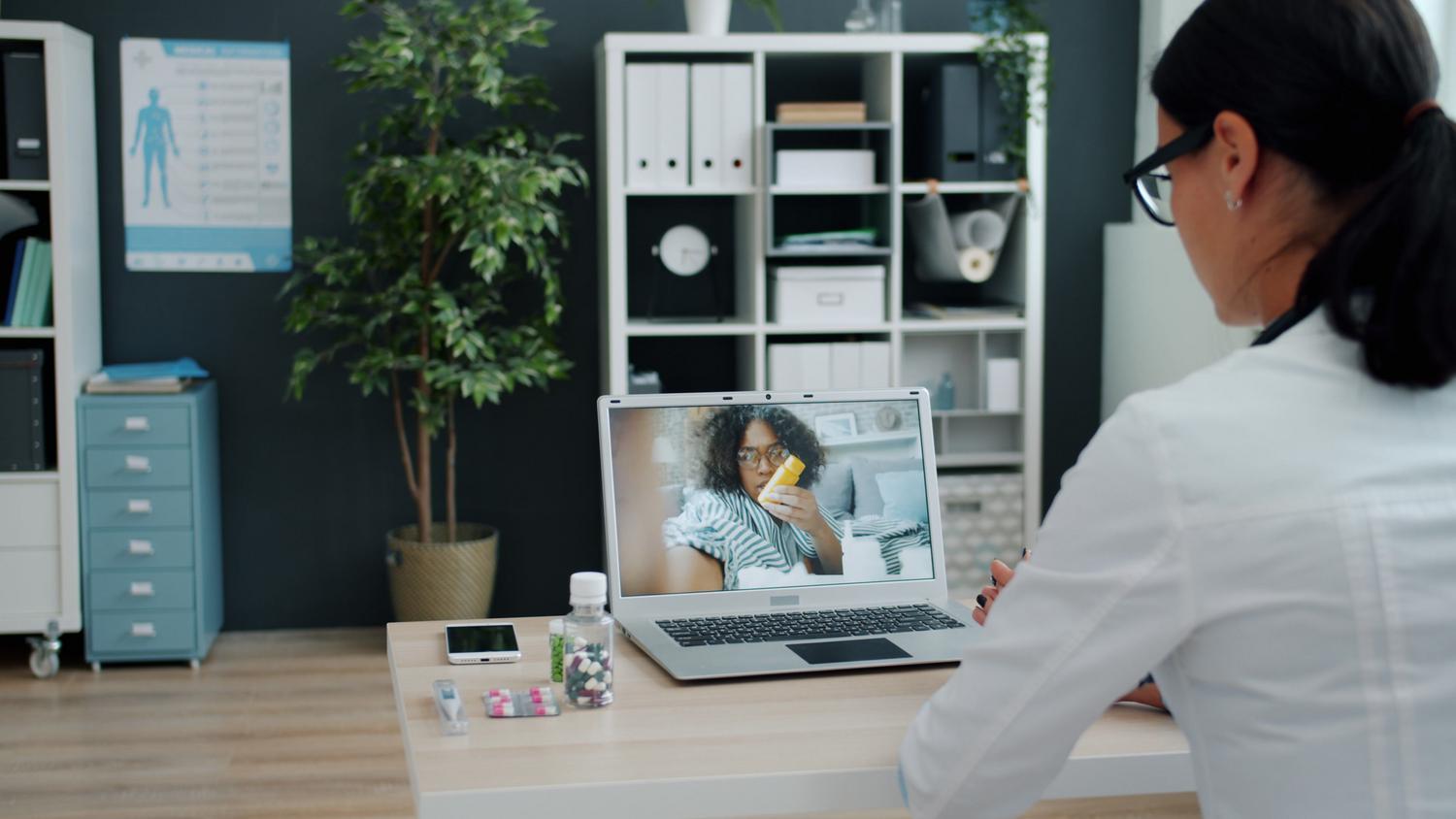 Formación online en dermatología pediátrica Médica realizando una consulta virtual a través de una videollamada en su oficina.