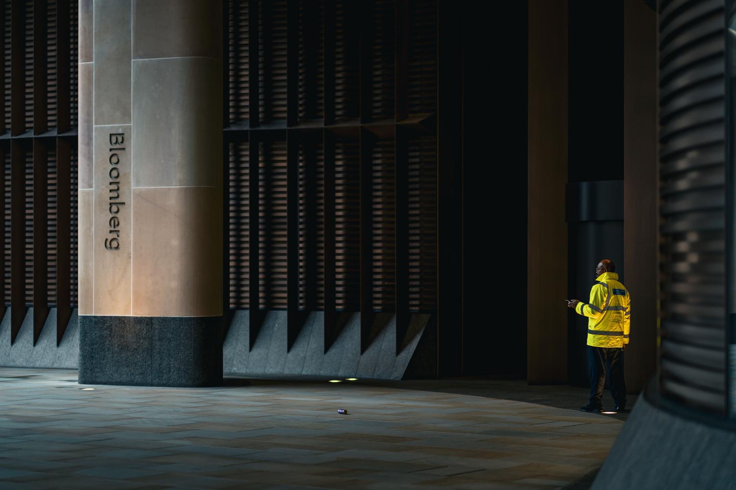Guardia de seguridad profesional vigilando la entrada de un edificio corporativo moderno en un entorno urbano. Guardia de seguridad profesional vigilando la entrada de un edificio corporativo moderno en un entorno urbano.