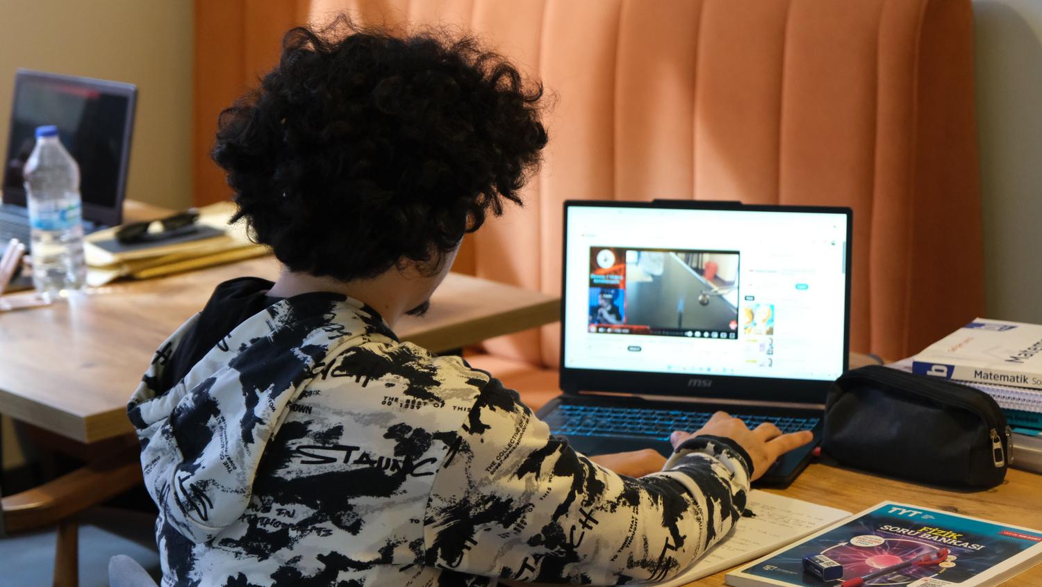 Estudiante joven realizando un curso de teleformación con ordenador portátil en casa, representando las modalidades online y subvencionadas Estudiante joven realizando un curso de teleformación con ordenador portátil en casa, representando las modalidades online y subvencionadas