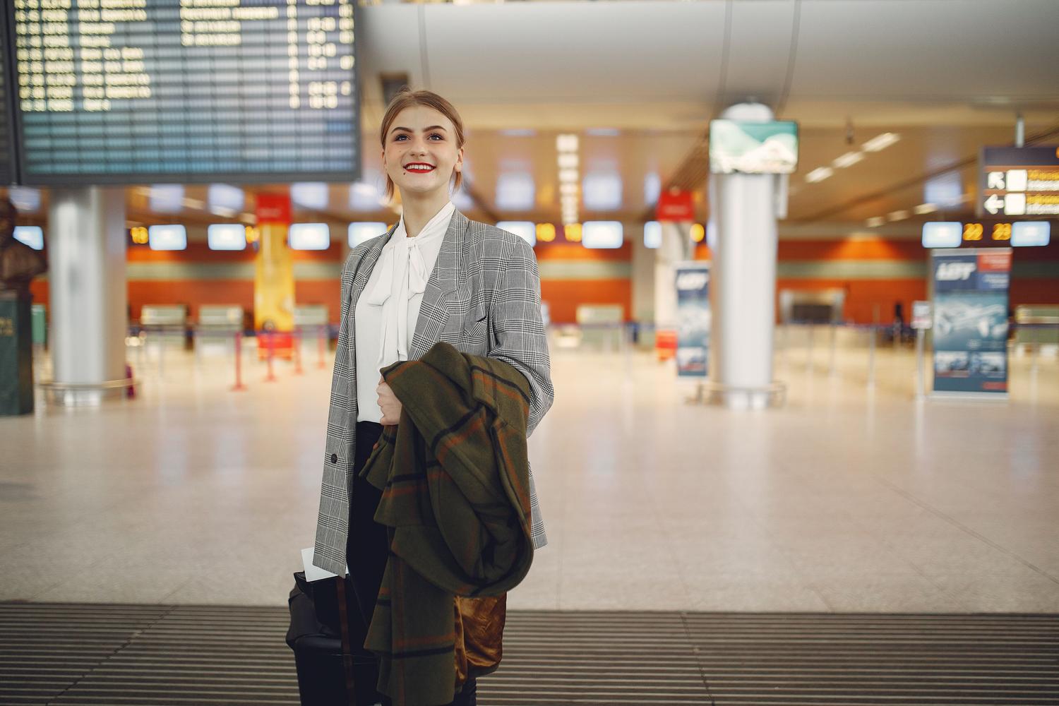 Profesional de atención al pasajero consultando el panel de vuelos en un aeropuerto Profesional de atención al pasajero consultando el panel de vuelos en un aeropuerto