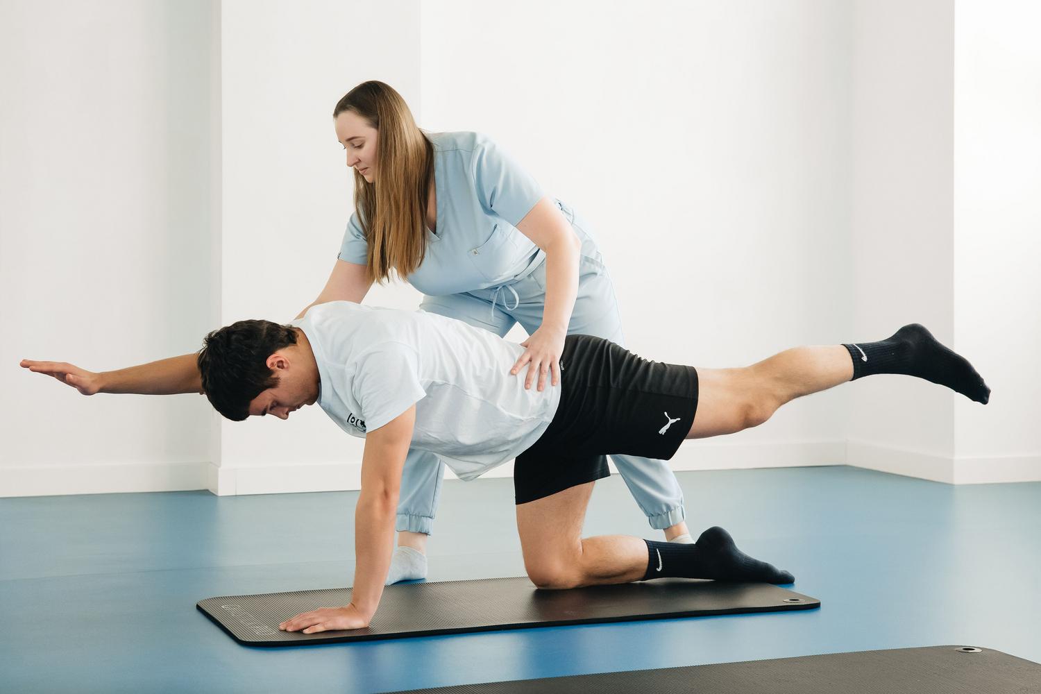 Fisioterapeuta guiando a un paciente en ejercicios de control motor y estabilización del núcleo en una clínica moderna Fisioterapeuta guiando a un paciente en ejercicios de control motor y estabilización del núcleo en una clínica moderna
