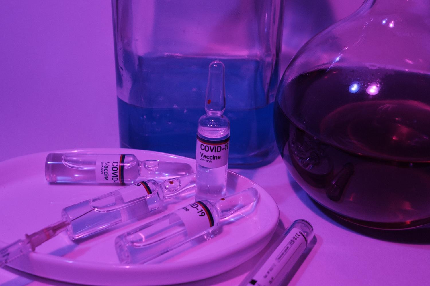 Vacunas y prevención viral Primer plano de ampollas de vacunas y frascos de vidrio con reactivos en un entorno de laboratorio clínico, enfocado en la prevención.