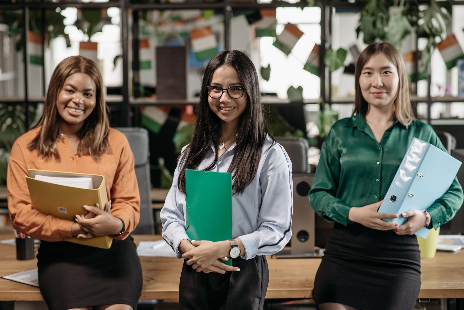Grupo de mujeres profesionales diversas y sonrientes en un entorno de oficina, ilustrando el empoderamiento y la inserción laboral femenina. Grupo de mujeres profesionales diversas y sonrientes en un entorno de oficina, ilustrando el empoderamiento y la inserción laboral femenina.