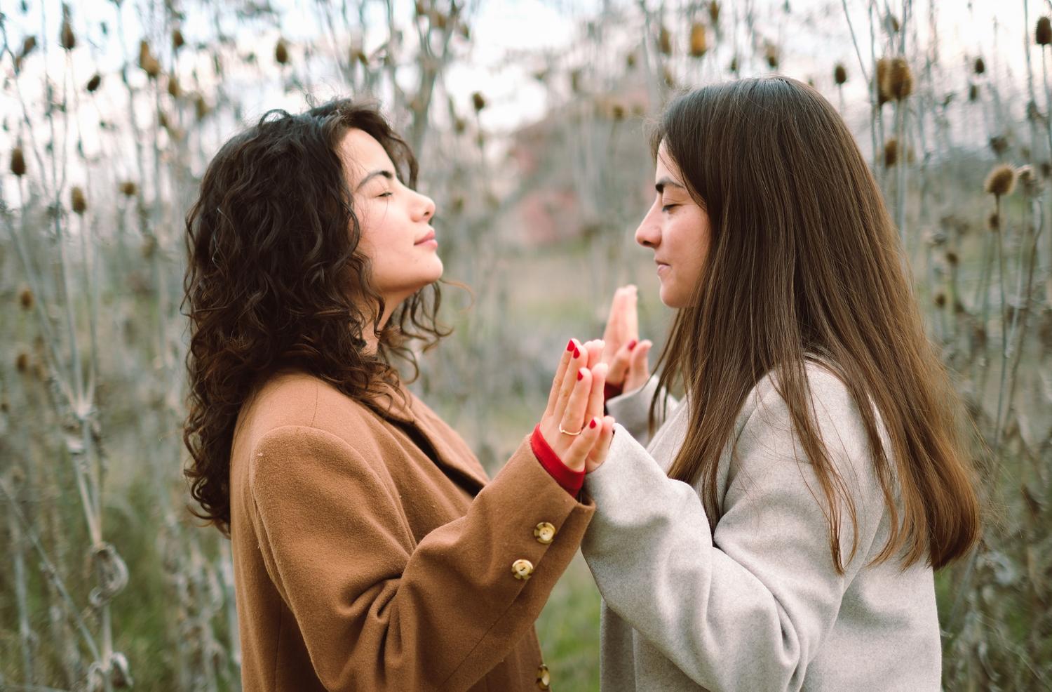 Dos mujeres practicando meditación consciente en la naturaleza, ilustrando la autorregulación y el mindfulness. Dos mujeres practicando meditación consciente en la naturaleza, ilustrando la autorregulación y el mindfulness.