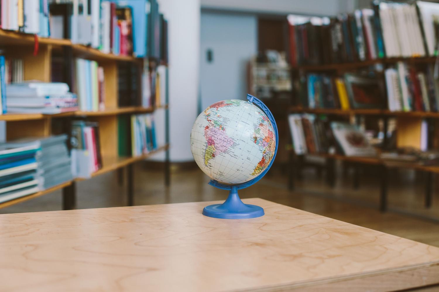 Un globo terráqueo en una biblioteca universitaria, simbolizando la trama global interconectada de la educación jesuita. Un globo terráqueo en una biblioteca universitaria, simbolizando la trama global interconectada de la educación jesuita.