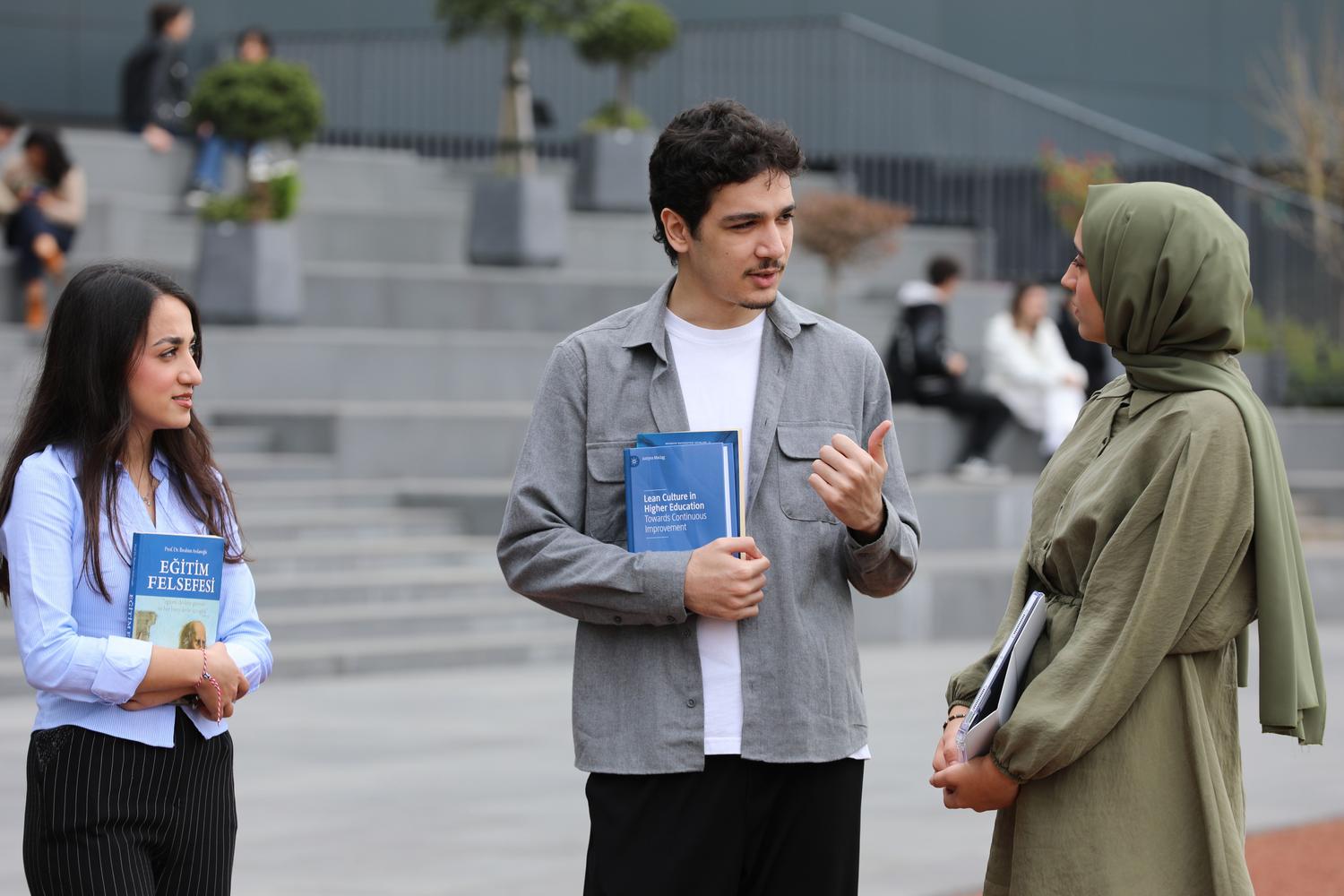 Estudiantes conversando en el campus universitario, representando la interacción y el asociacionismo estudiantil. Estudiantes conversando en el campus universitario, representando la interacción y el asociacionismo estudiantil.