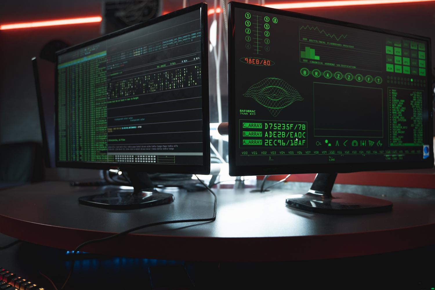 Monitores con código de programación en un entorno oscuro, ilustrando la detección de amenazas y el AI Blue Teaming. Monitores con código de programación en un entorno oscuro, ilustrando la detección de amenazas y el AI Blue Teaming.