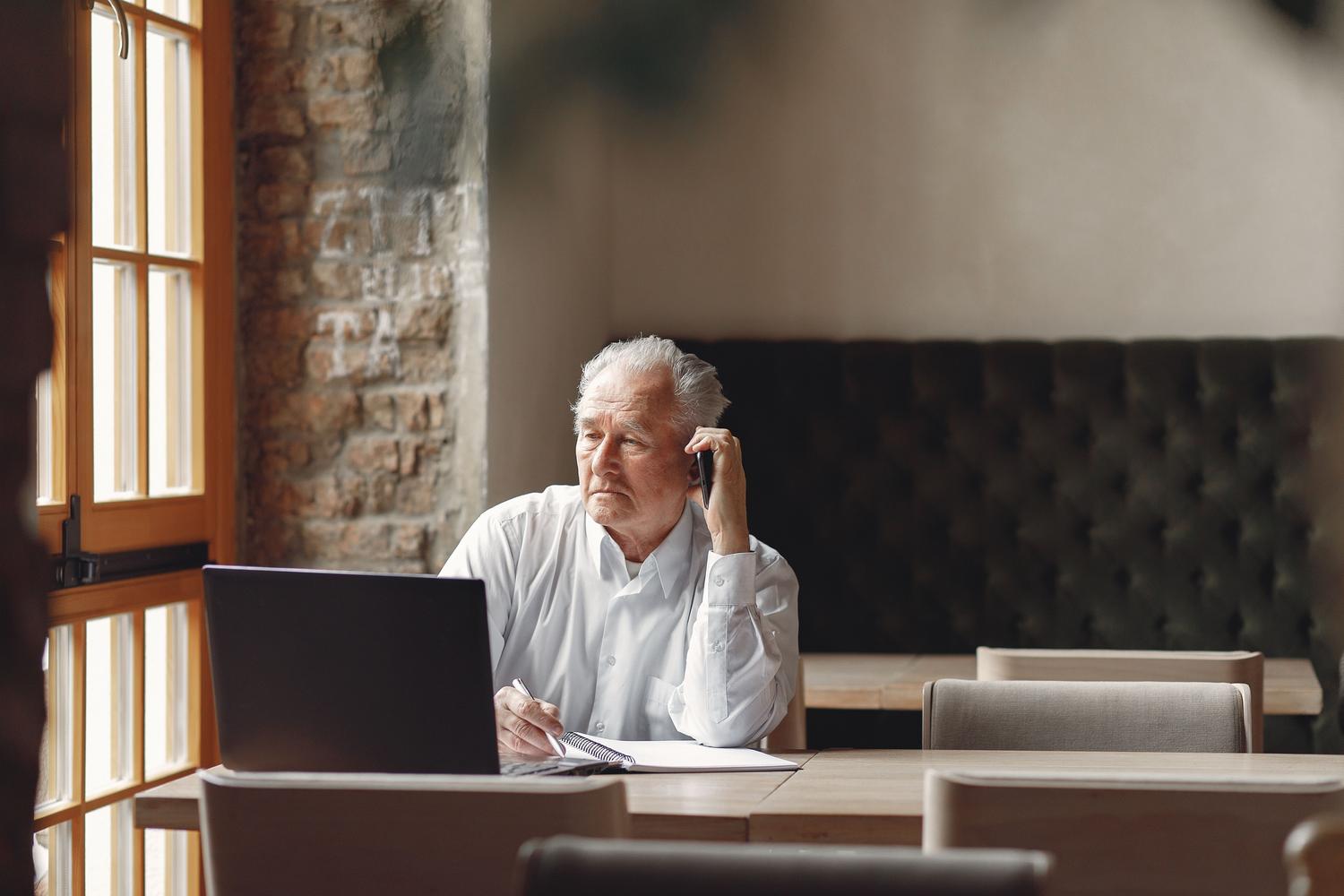 Hombre senior reflexivo planificando su futuro laboral y financiero en un espacio de trabajo creativo. Hombre senior reflexivo planificando su futuro laboral y financiero en un espacio de trabajo creativo.