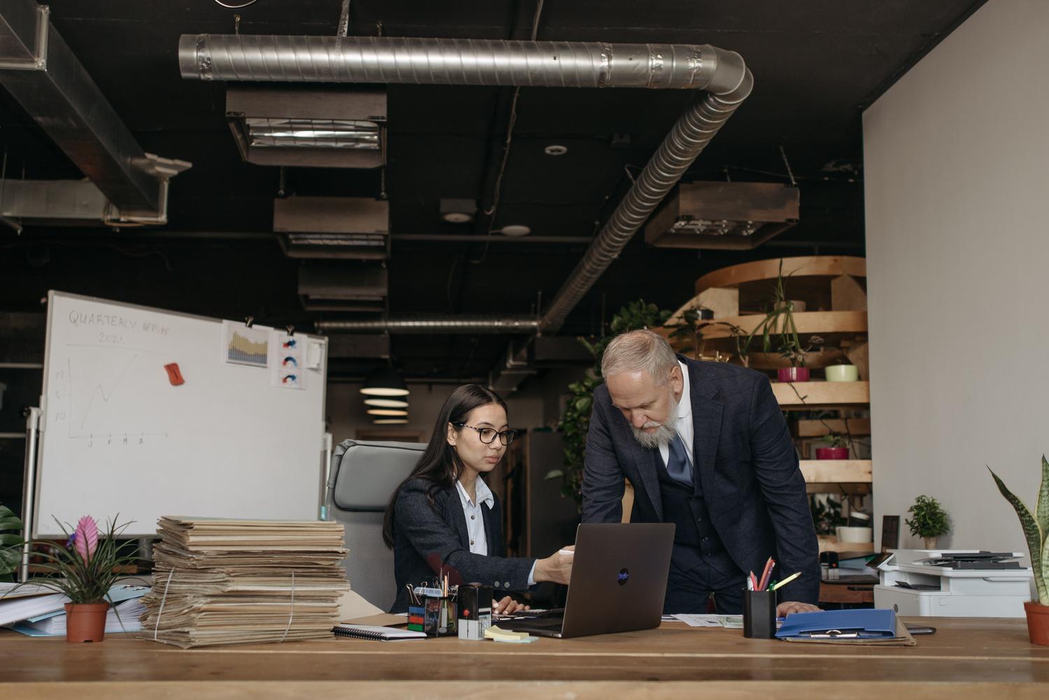 Colaboración profesional entre un hombre senior y una colega en un entorno de oficina contemporáneo. Colaboración profesional entre un hombre senior y una colega en un entorno de oficina contemporáneo.