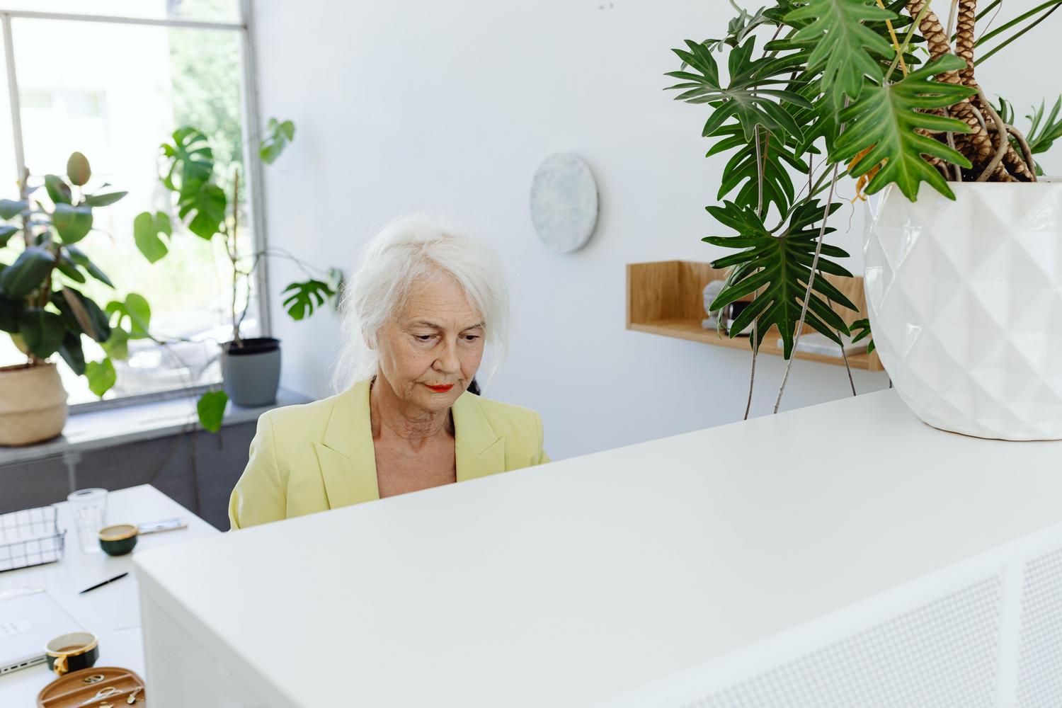 Mujer senior profesional concentrada trabajando en una oficina moderna y luminosa. Mujer senior profesional concentrada trabajando en una oficina moderna y luminosa.