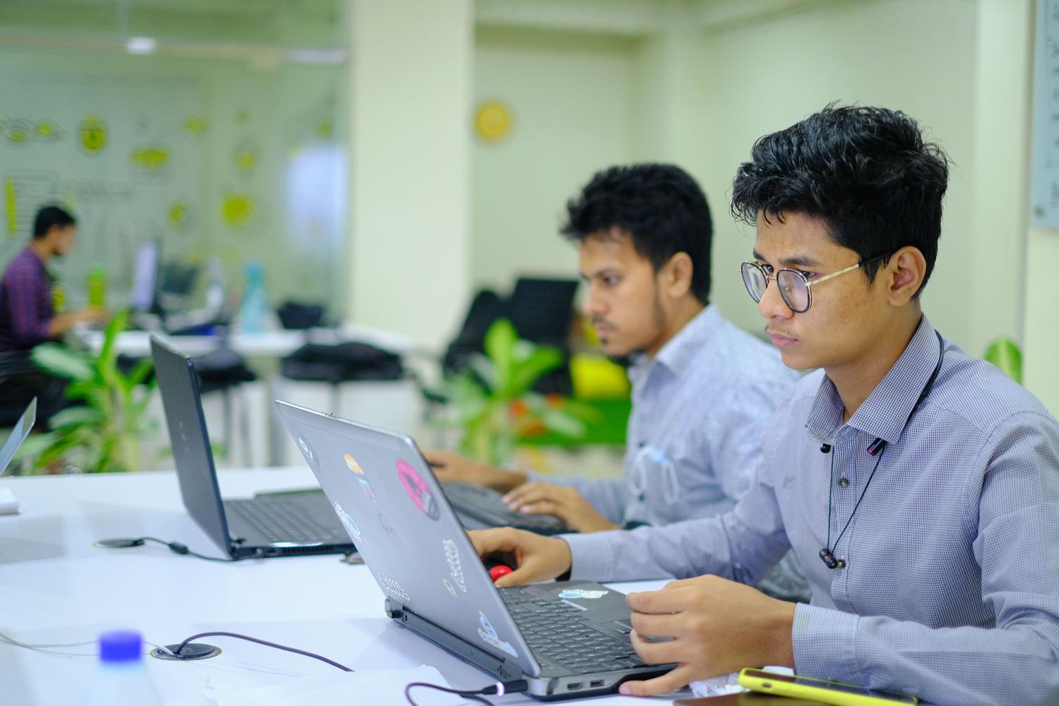 Jóvenes profesionales trabajando con portátiles en una oficina moderna y luminosa, aplicando sus habilidades digitales. Jóvenes profesionales trabajando con portátiles en una oficina moderna y luminosa, aplicando sus habilidades digitales.