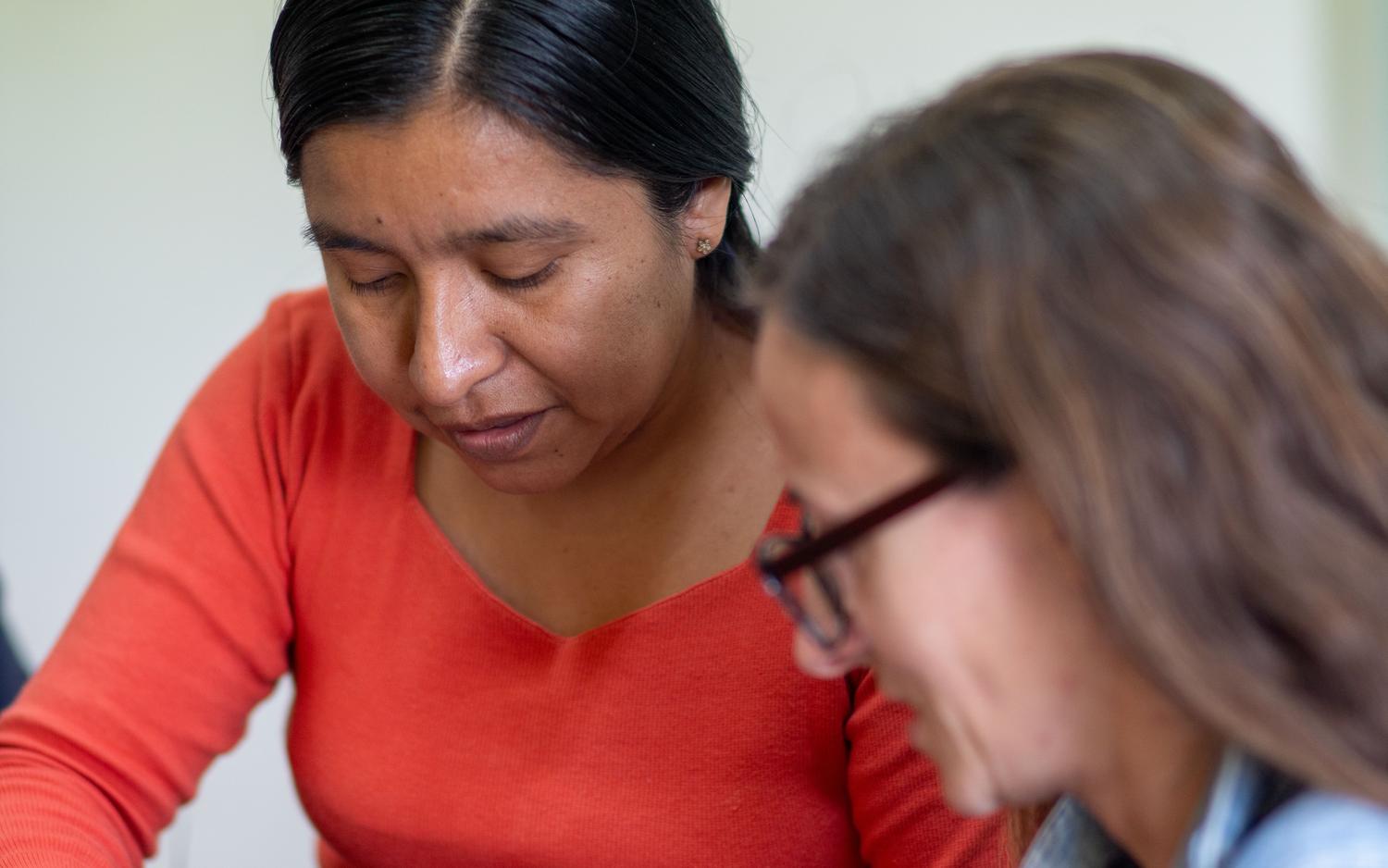 Evaluación docente entre iguales impulsada por IA Dos profesoras trabajando juntas en una sesión de retroalimentación formativa y mentoría pedagógica.