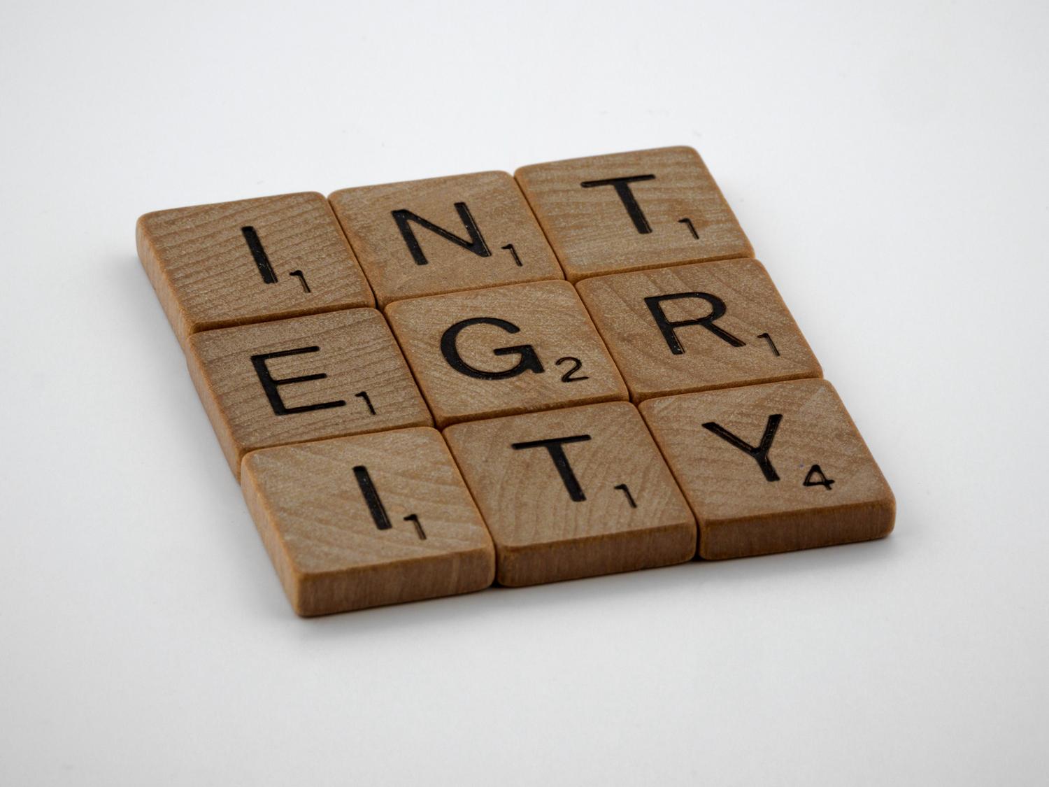 Letras de madera formando la palabra INTEGRITY sobre un fondo blanco, simbolizando la honestidad y los valores éticos en la ciencia. Letras de madera formando la palabra INTEGRITY sobre un fondo blanco, simbolizando la honestidad y los valores éticos en la ciencia.