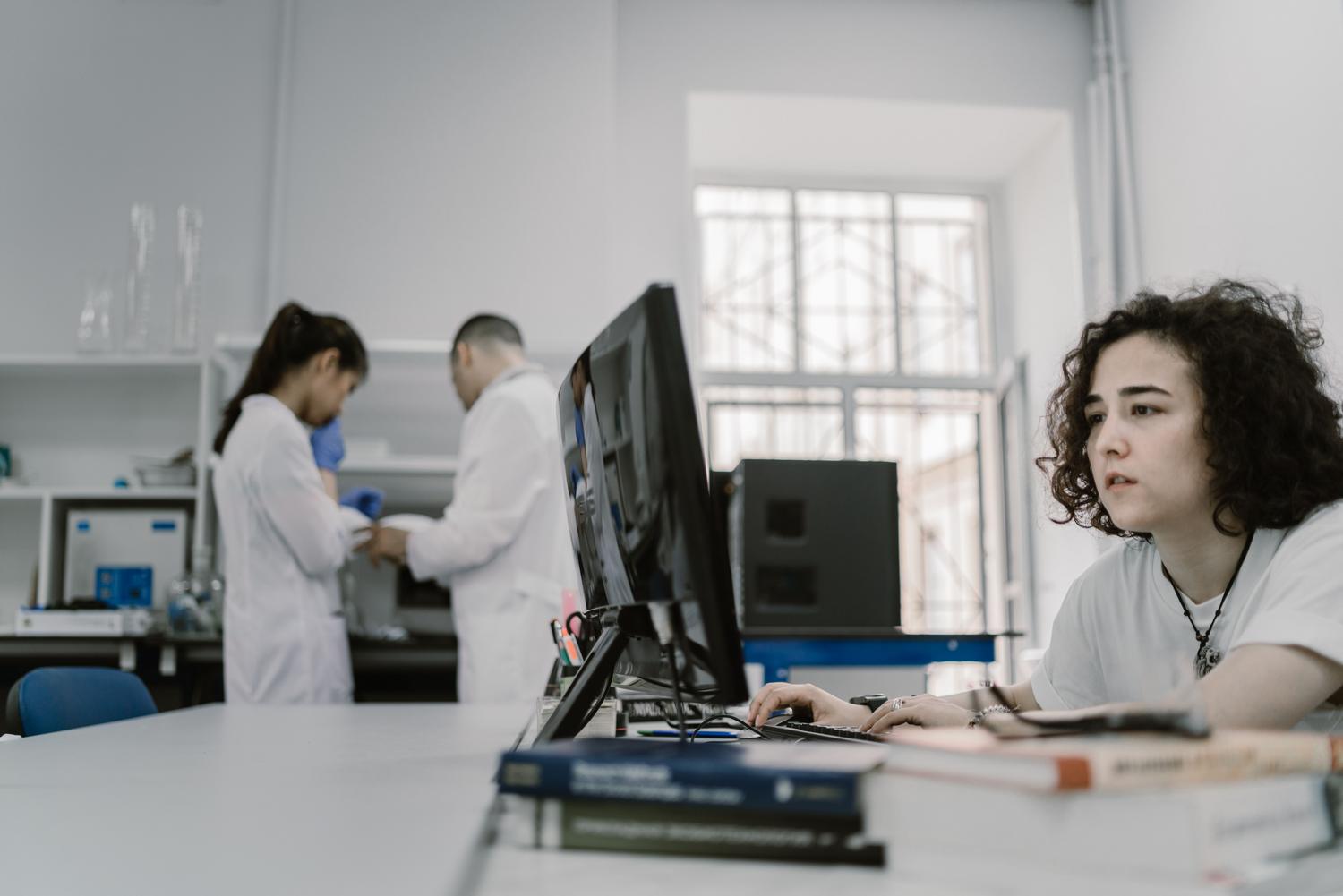 Investigadora trabajando con un ordenador en un entorno de laboratorio, representando la intersección entre la tecnología, el análisis de datos y la ética moderna. Investigadora trabajando con un ordenador en un entorno de laboratorio, representando la intersección entre la tecnología, el análisis de datos y la ética moderna.