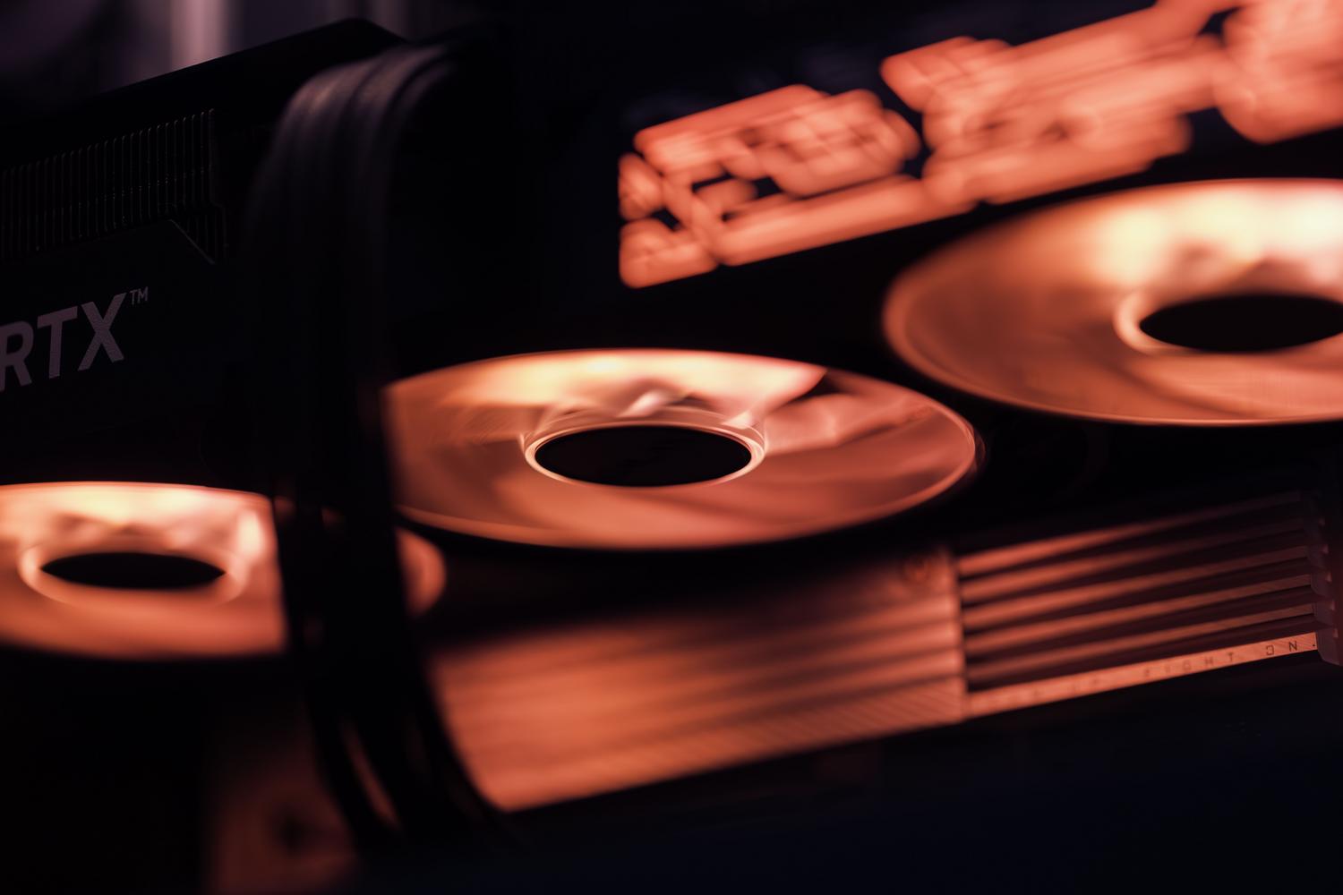 Refrigeración de una tarjeta gráfica Detalle de los ventiladores de una tarjeta gráfica iluminados con luz roja, ideal para ilustrar la refrigeración del hardware.