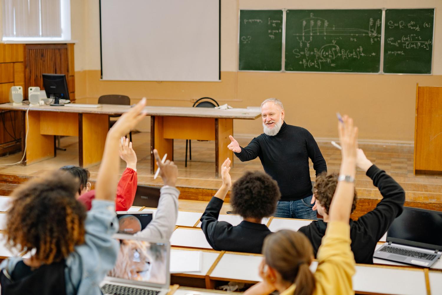 University professor interacting with students in a classroom, representing secondary school positions and other teaching bodies. University professor interacting with students in a classroom, representing secondary school positions and other teaching bodies.