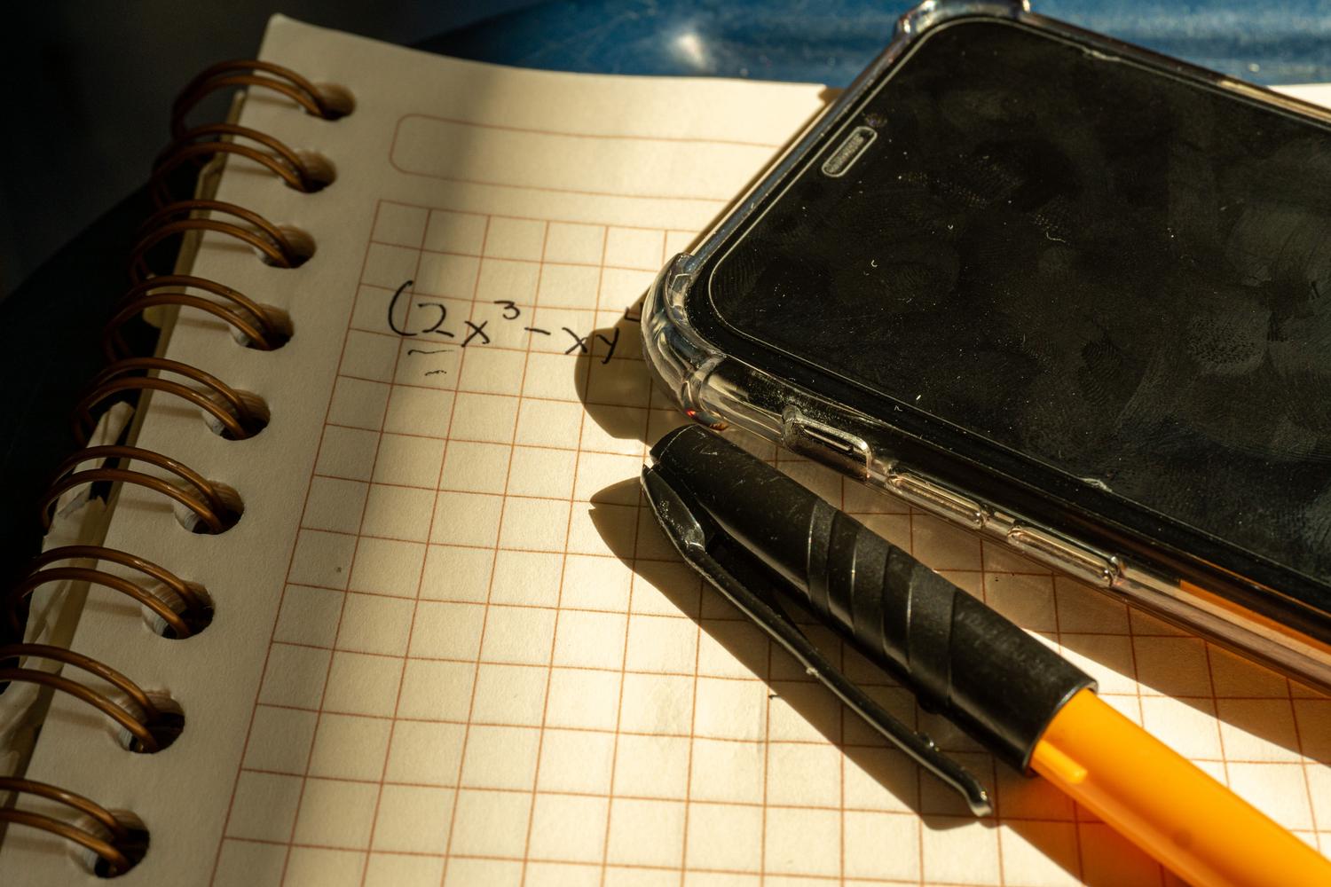 Cuaderno con ejercicios matemáticos junto a un smartphone, reflejando la transición entre el cálculo tradicional y el uso de herramientas digitales para la aplicación práctica. Cuaderno con ejercicios matemáticos junto a un smartphone, reflejando la transición entre el cálculo tradicional y el uso de herramientas digitales para la aplicación práctica.