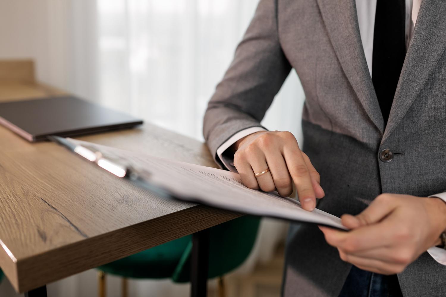 Profesional del derecho estudiando detalladamente un documento legal en una oficina moderna Profesional del derecho estudiando detalladamente un documento legal en una oficina moderna