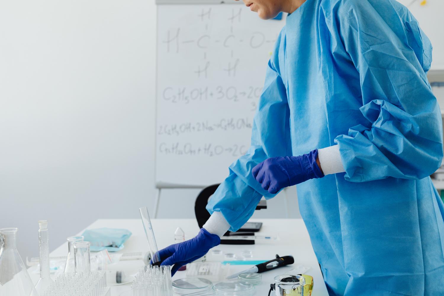Profesional de laboratorio utilizando equipo de protección personal (PPE) mientras manipula muestras, destacando la seguridad laboral. Profesional de laboratorio utilizando equipo de protección personal (PPE) mientras manipula muestras, destacando la seguridad laboral.