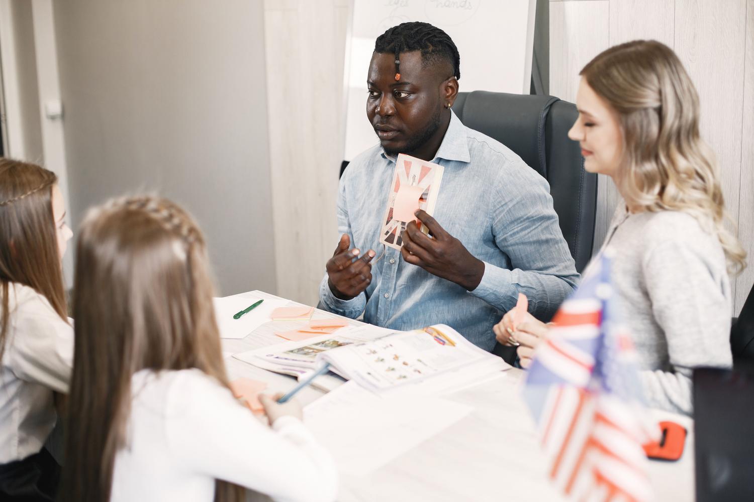 Teacher guiding students in an English class with a British flag card Teacher guiding students in an English class with a British flag card